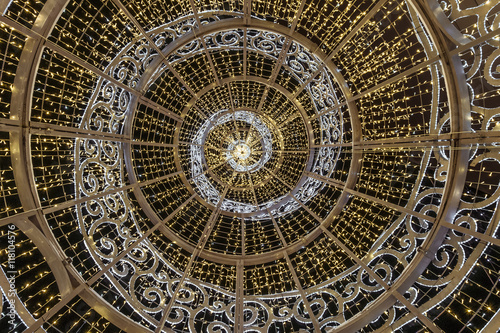 Garland coiled on a large steel frame  simulates a festive Christmas tree. View from inside the carcass.