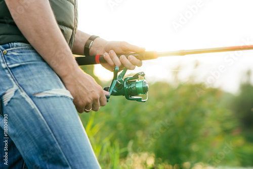 Fisherman with a spinning rod catching fish in a river