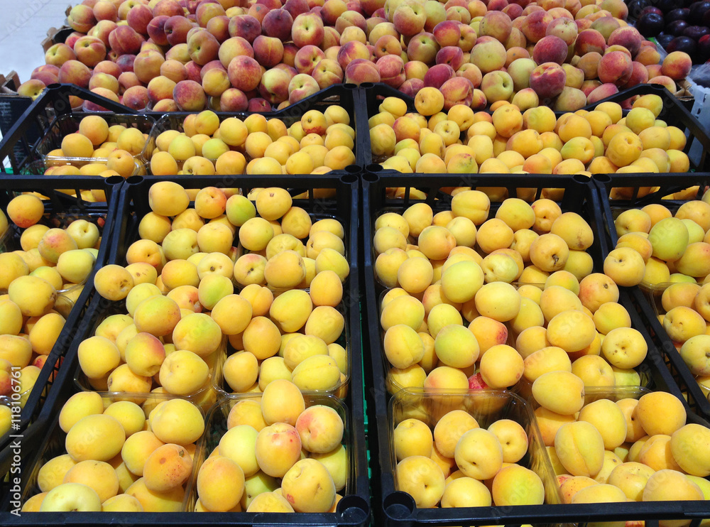 Many fruits apricots and peaches lying in boxes in supermarket Many fruits apricots and peaches lying in boxes in supermarket