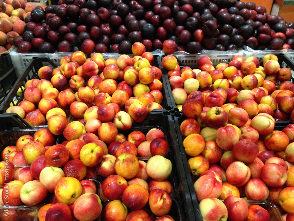 Many fruits nectarines and plums lying in boxes in supermarket Many fruits nectarines and plums lying in boxes in supermarket