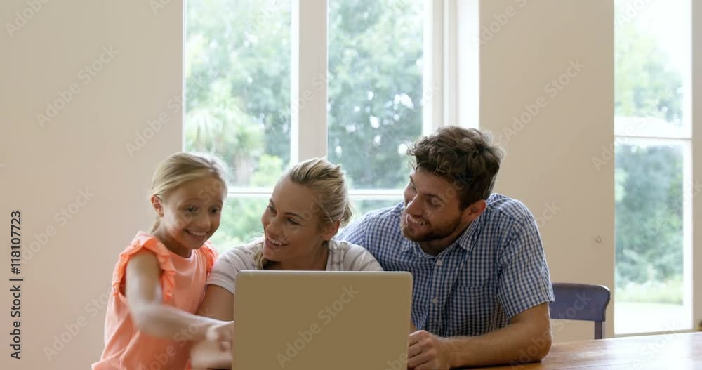 A family of three is using laptop in the living room A family of three is using laptop in the living room
