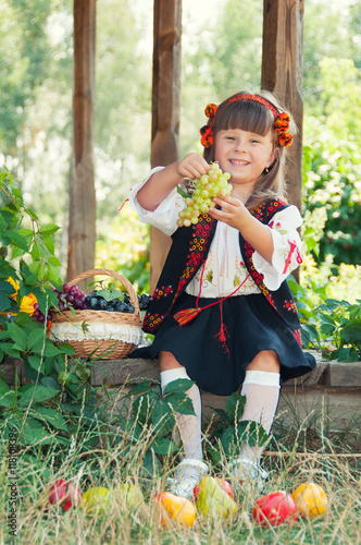 Little Ukrainian girl in national costume sitting on the porch