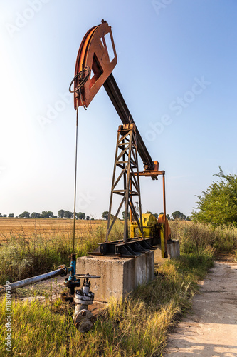 A small private oil derrick pumps oil on the field. 