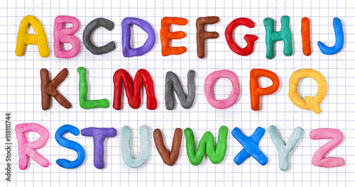 Handmade plasticine alphabet with shadow on notebook sheet. English colorful letters of modelling clay.