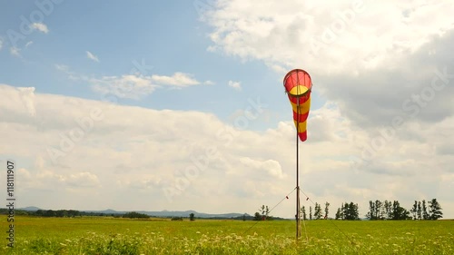 Summer hot day on sport airport with abandoned windsock, wind is blowing and windsock is moving photo