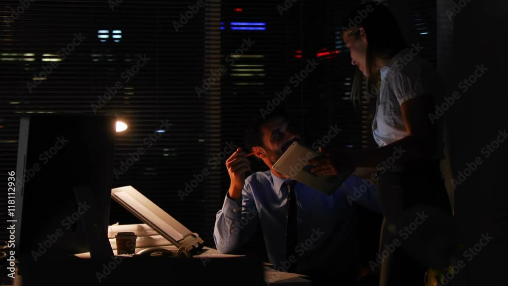 Colleagues using a tablet at night