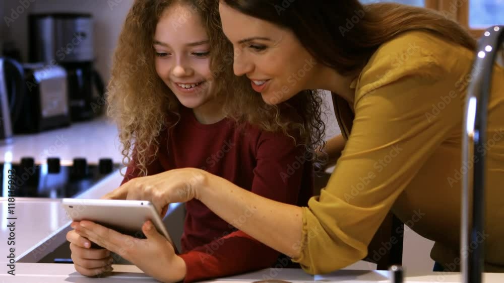 Daughter and mother are looking a tablet on a bed Daughter and mother are looking a tablet on a bed