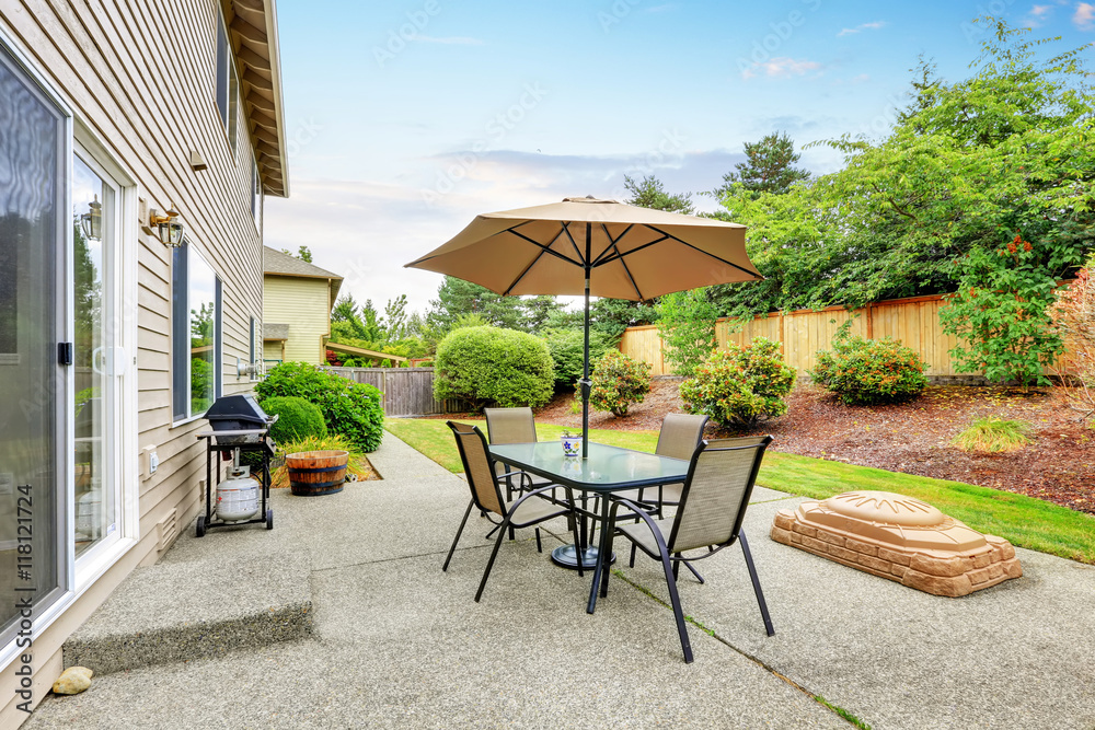 Patio table set with umbrella in the back yard. Patio table set with umbrella in the back yard.