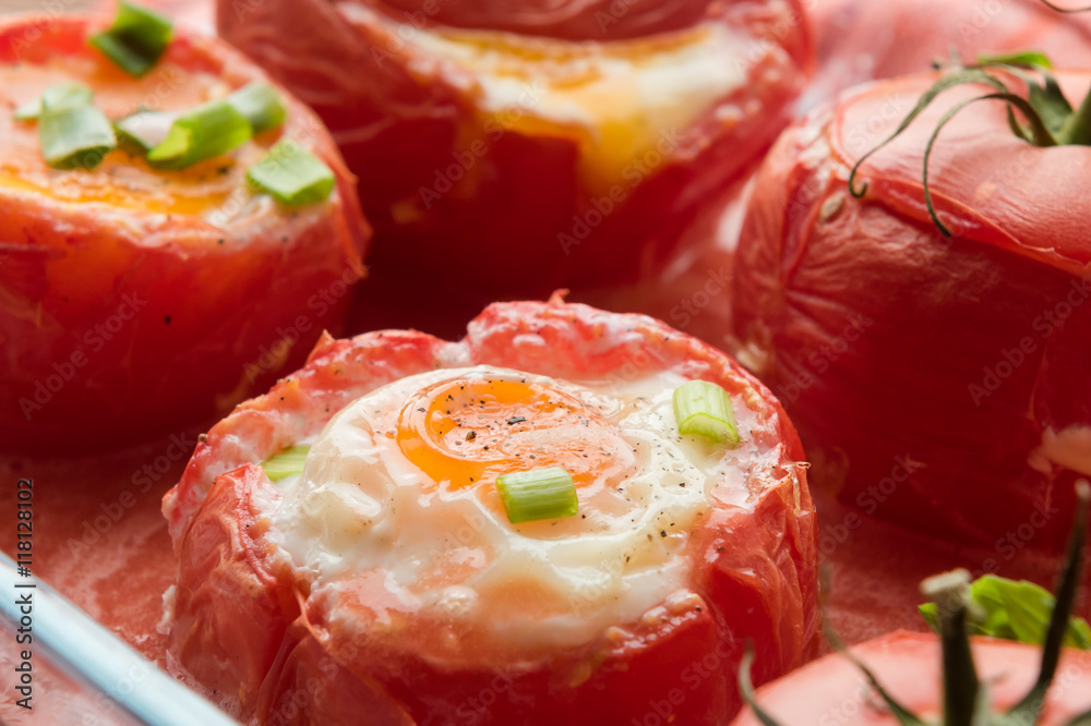 Eggs with rosemary and basil baked in tomato, top view. Eggs with rosemary and basil baked in tomato, top view.