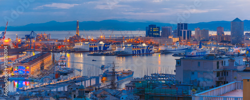 Panorama of Historical Lanterna old Lighthouse, container and passenger terminals in seaport of Genoa on Mediterranean Sea, at night, Italy. photo