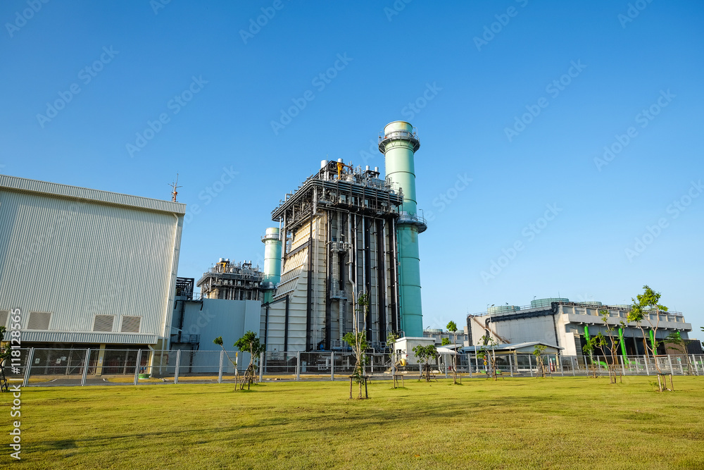 Combine cycle power plant with green field and clear sky Combine cycle power plant with green field and clear sky