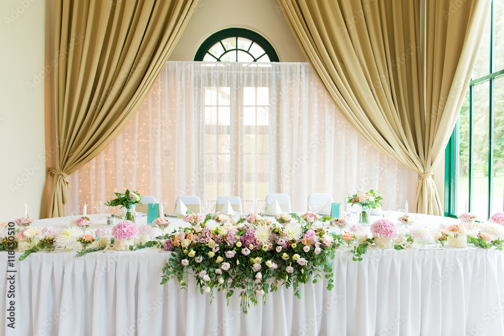 Indoors wedding reception venue with décor, selective focus on flowers
