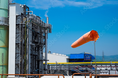 a windsock inflated by the wind on the sky against power plant b