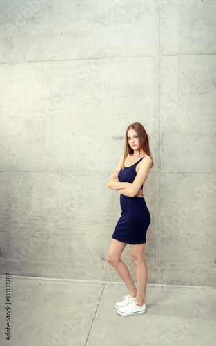 Young woman standing - wall surrounding her for copy space