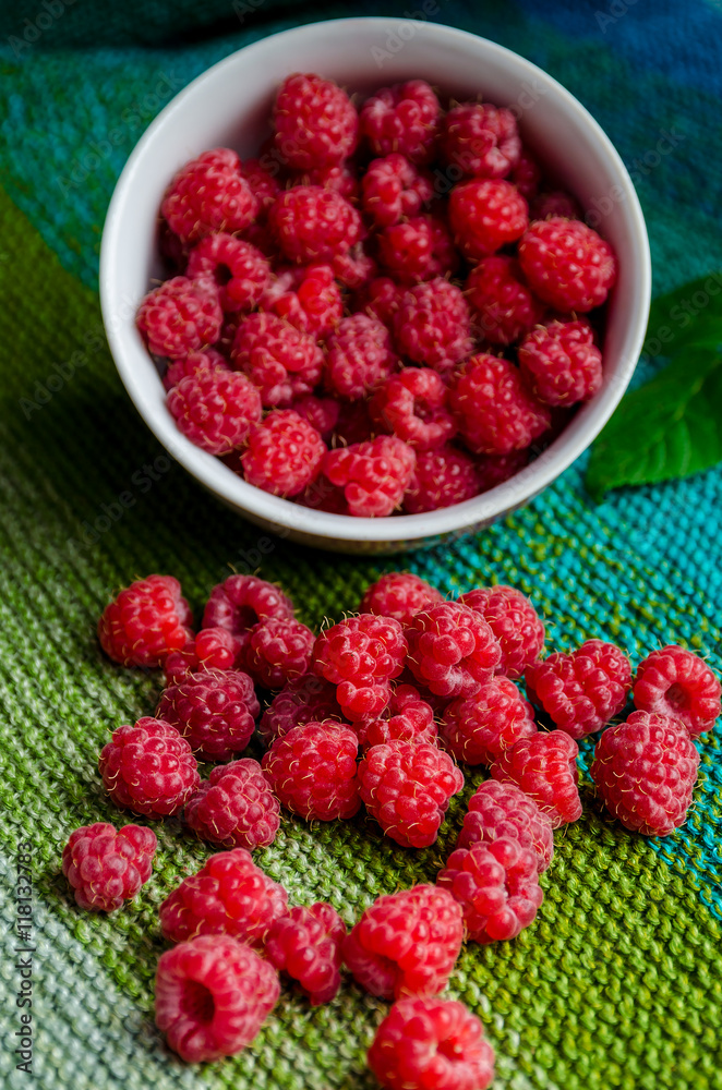 plate bent and ripe raspberries crumbled on linen green cloth plate bent and ripe raspberries crumbled on linen green cloth