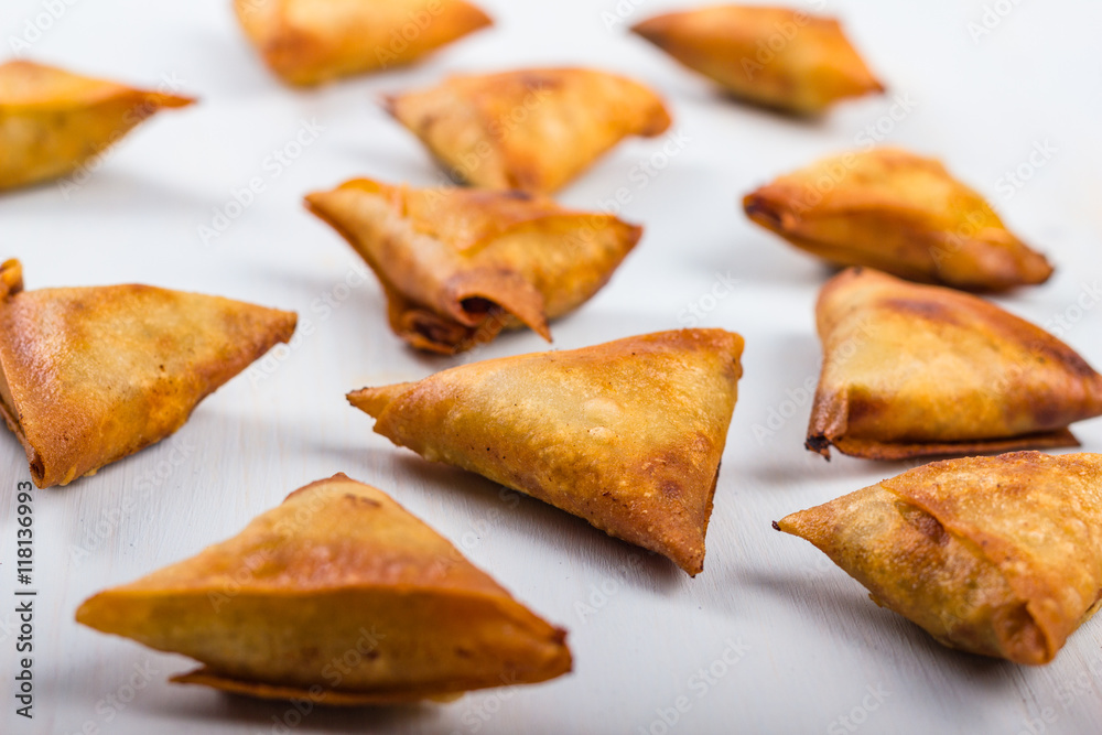 Gold and brown deep fried chicken samosas.