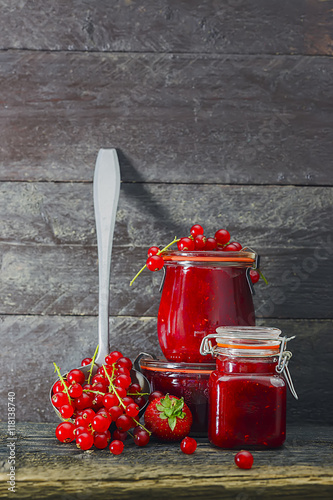  Marmelade im Glas mit frischen Beeren,  rustikaler Hintergrund