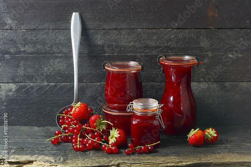  Marmelade im Glas mit frischen Beeren,  rustikaler Hintergrund