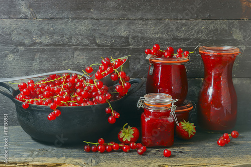  Marmelade im Glas mit frischen Beeren,  rustikaler Hintergrund