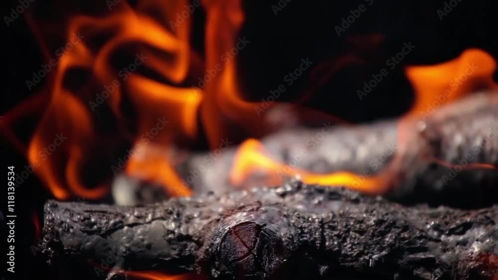 branches of cherry wood stacked in a barbecue burning bright red flames branches of cherry wood stacked in a barbecue burning bright red flames