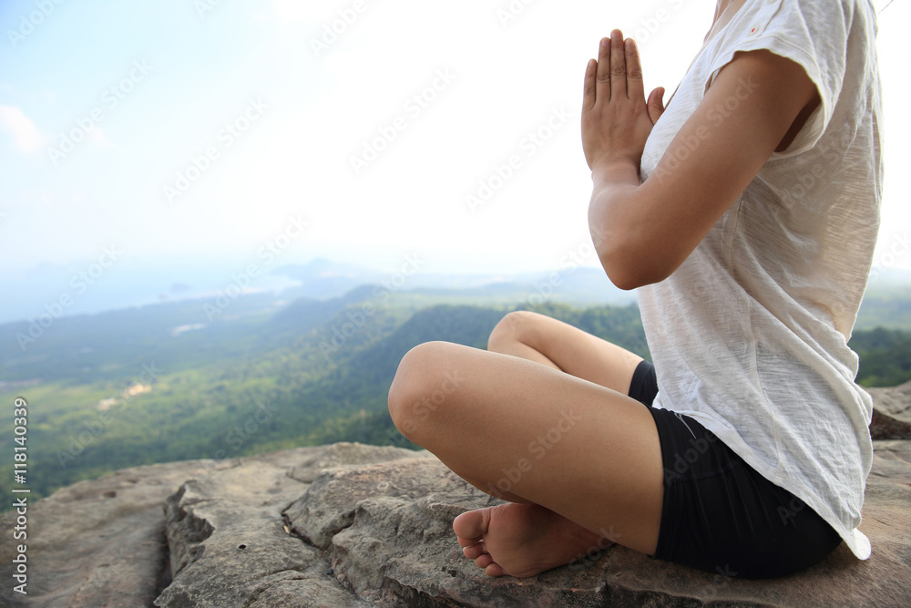 young fitness woman practice yoga at mountain peak cliff
