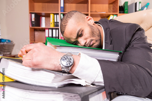 Wallpaper Mural overworked tired african man lay on folders in the office Torontodigital.ca