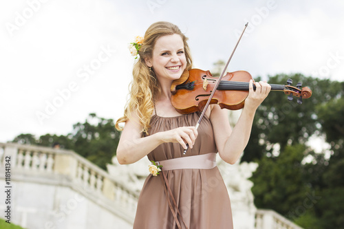 Canvas Print Beautiful smiling girl playing on the violin outdoors