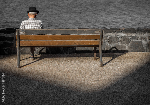 Old man sitting on a wooden bench