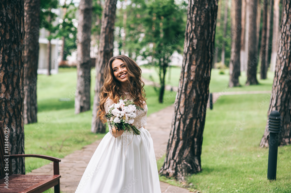 beautiful bride with white bouquet in park