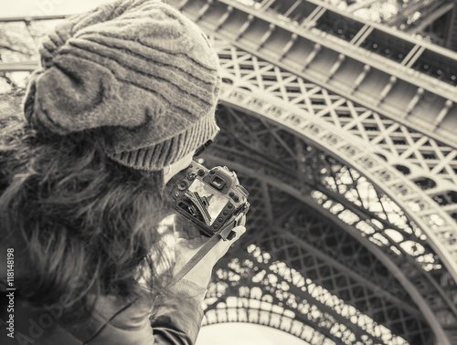 Girl taken pictures Eiffel Tower.