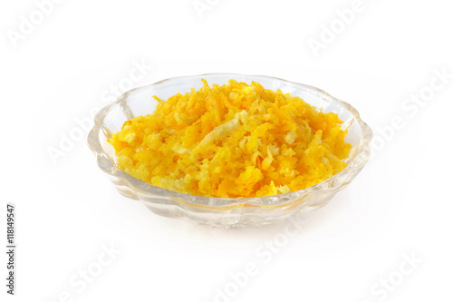 Foto Fresh orange zest grated in small glass bowl isolated on white background