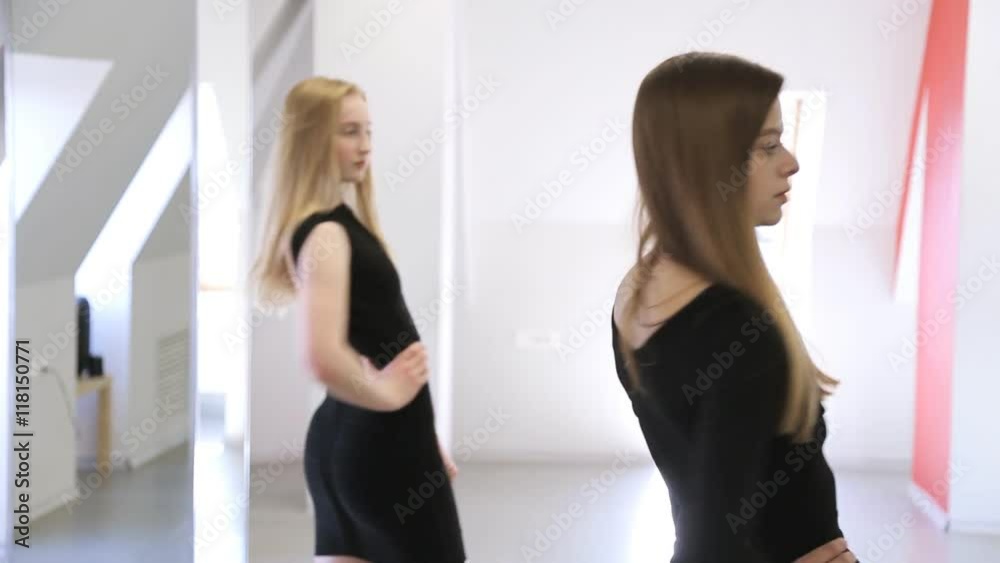 Attractive girls train to stay in half-turned position in studio Attractive girls train to stay in half-turned position in studio