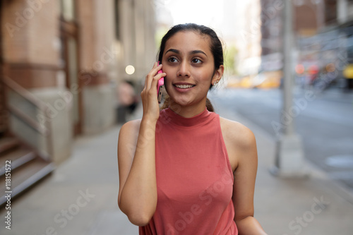 Young woman in city talking on cell pohne