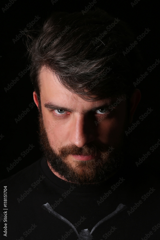 Bearded man looking into the camera. Close.up. Black