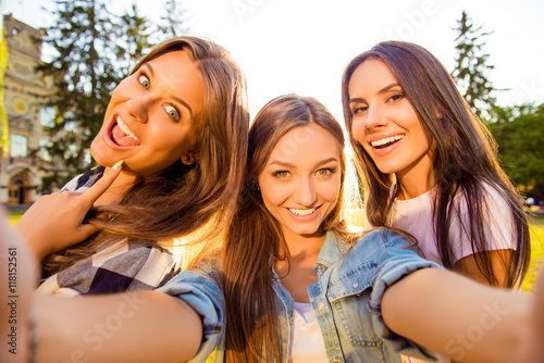 three attractive cheerful best girlfriends with toothy smile mak