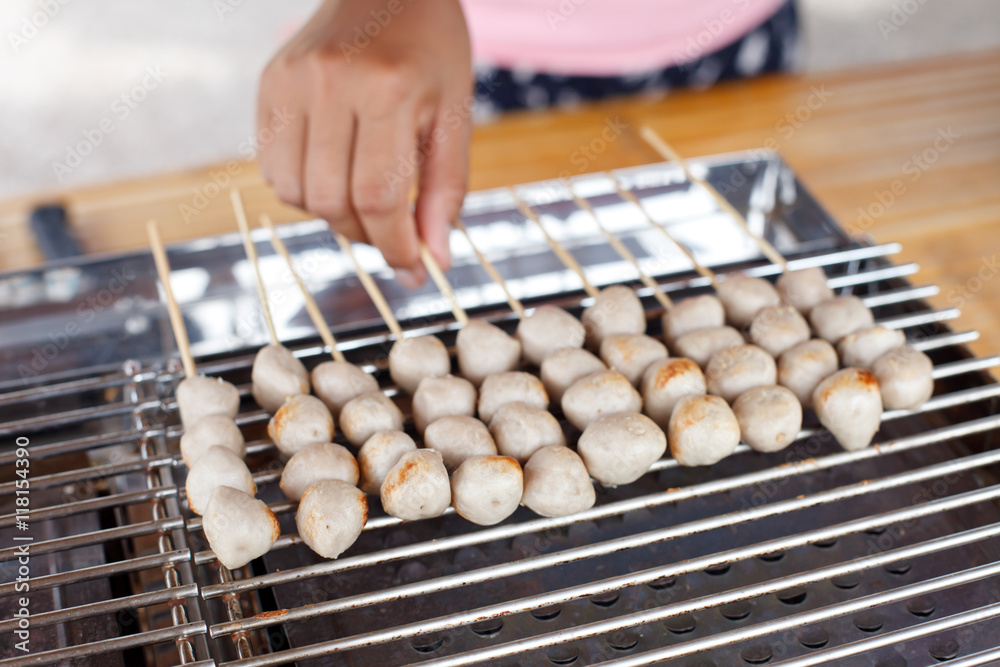 Meatballs on skewers being grilled on a barbecue Meatballs on skewers being grilled on a barbecue