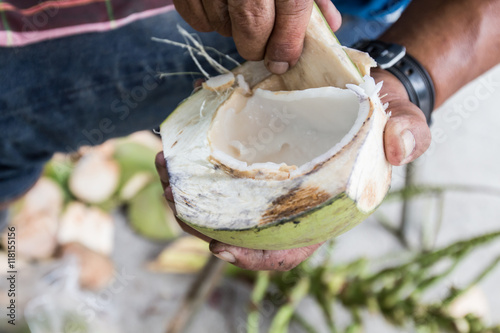 Man's use coconut shell to Grated coconut.