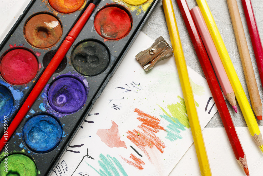 Naklejka premium Watercolor paint box and colorful crayons