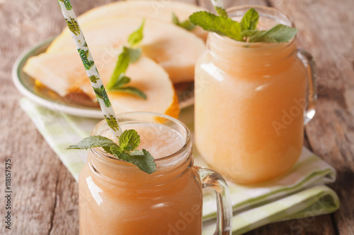 Tasty smoothies of melon with mint macro in a glass jar. horizontal
 photo