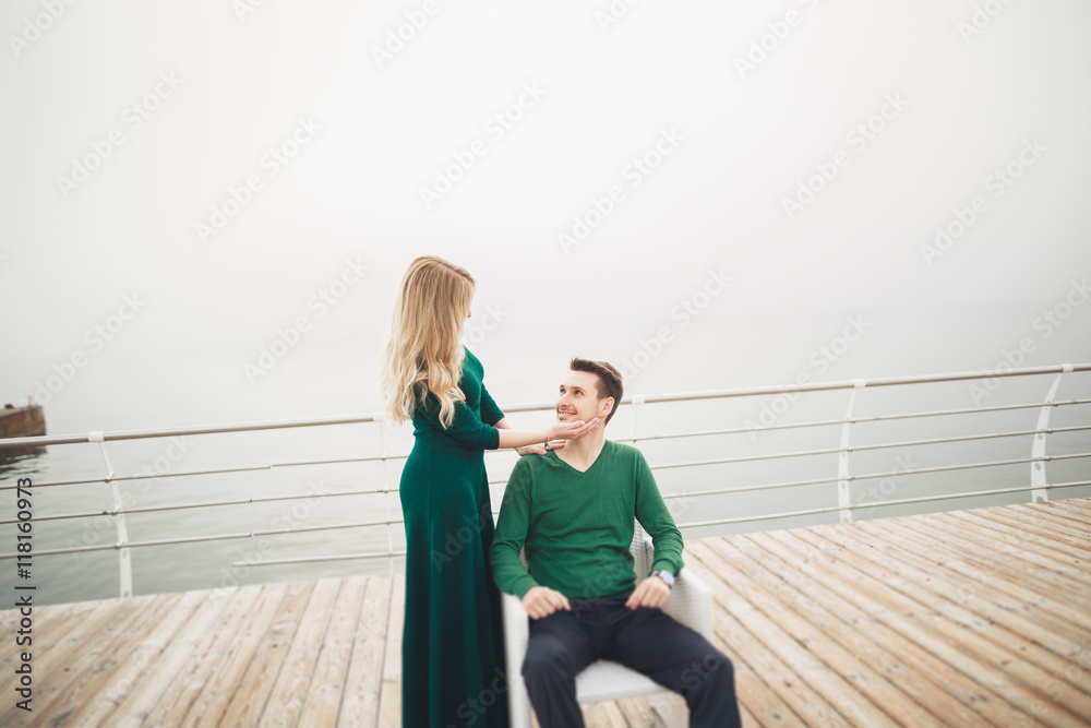 Lovely couple kissing and hugging on a sea dock Lovely couple kissing and hugging on a sea dock