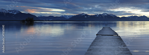 Wooden Pier into Lake Chiemsee at Sunset agains the Bavarian Alps, Bavaria, Germany photo