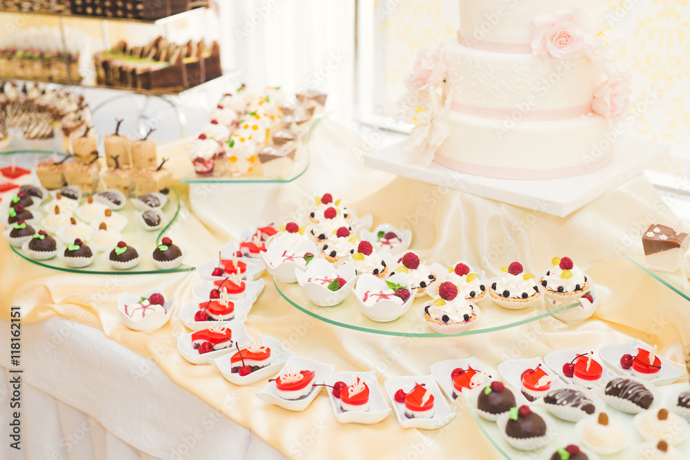 Naklejka premium Delicious and tasty dessert table with cupcakes shots at reception closeup