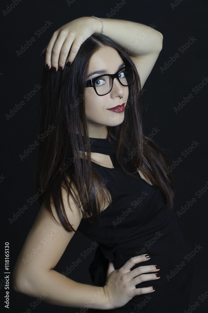 Stylish girl with big glasses on a black background.. Stylish girl with big glasses on a black background..