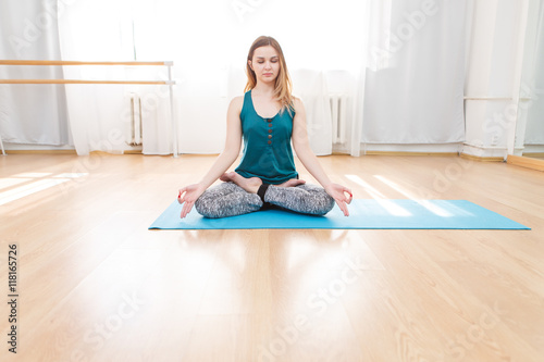 Portrait of young blonde woman meditating in lotus pose