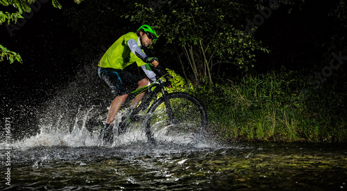 Fototapeta Naklejka Na Ścianę i Meble -  Mountain biker riding in forest stream