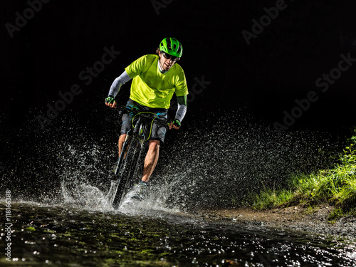 Mountain biker riding in forest stream