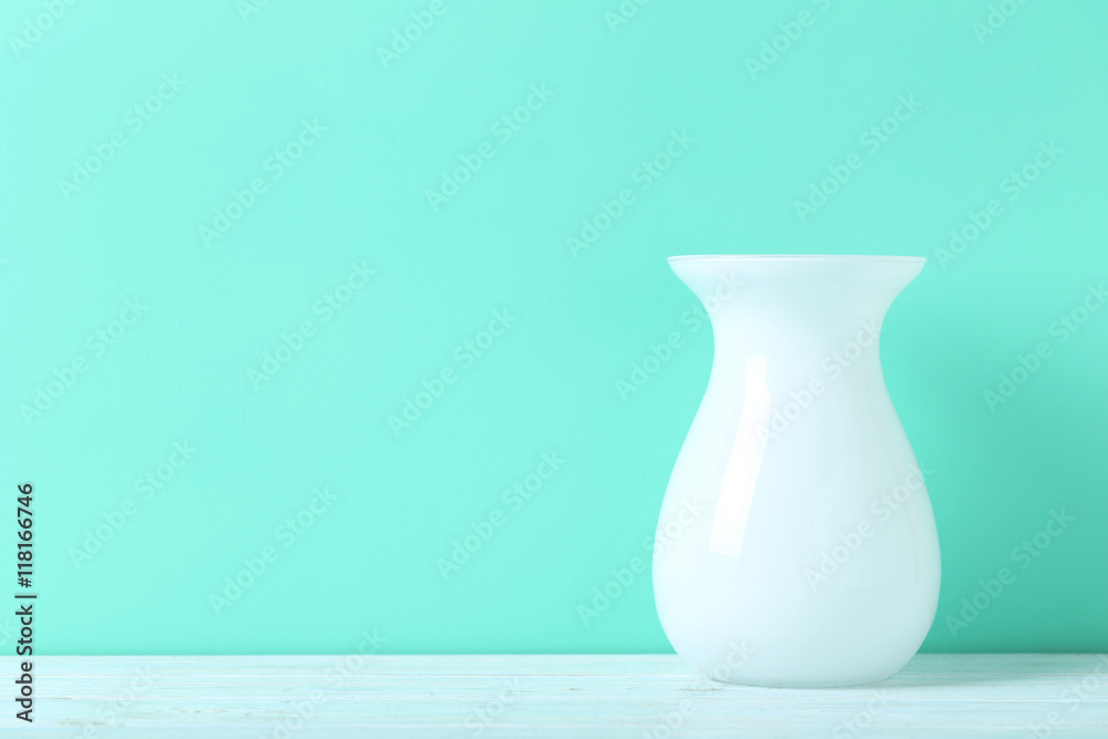 White vase on blue wooden table White vase on blue wooden table