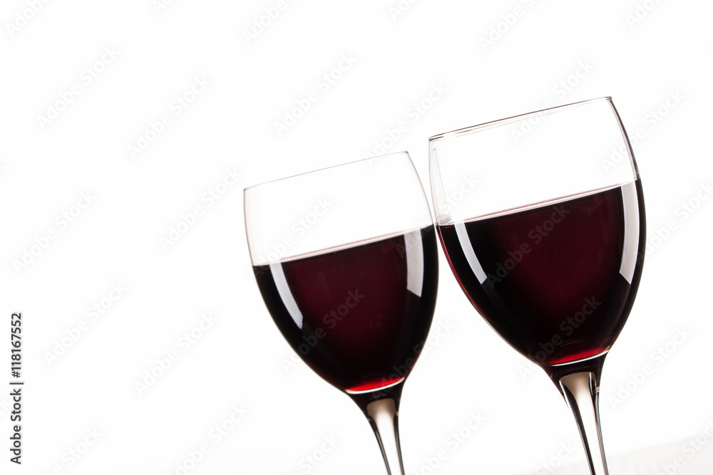 Zwei gefüllte Rotweingläser vor weißem Hintergrund. Makro