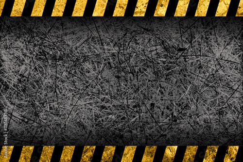Grunge dark grey background with black and yellow warning stripes
