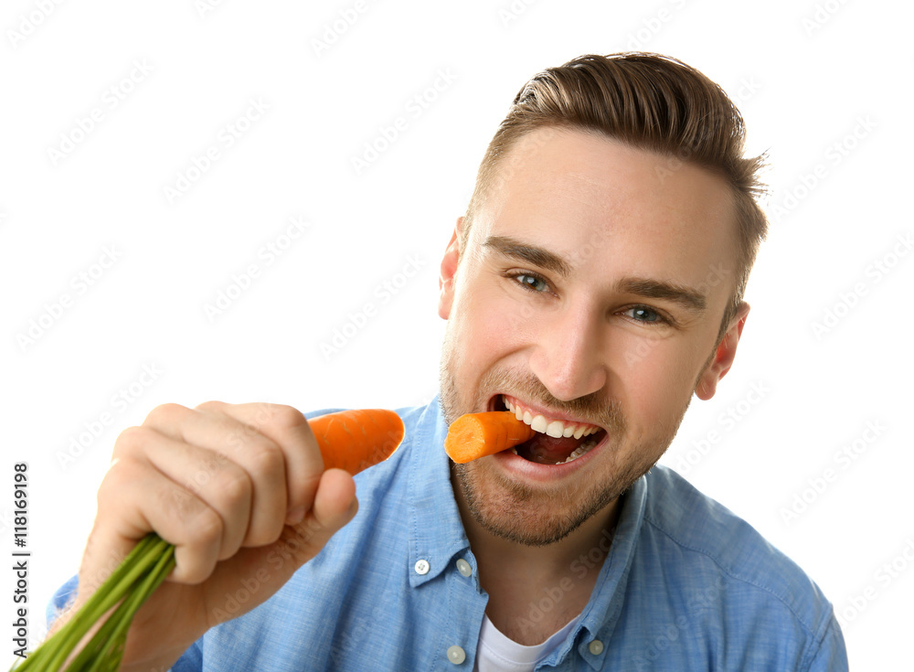 Handsome man eating carrot, isolated on white Handsome man eating carrot, isolated on white